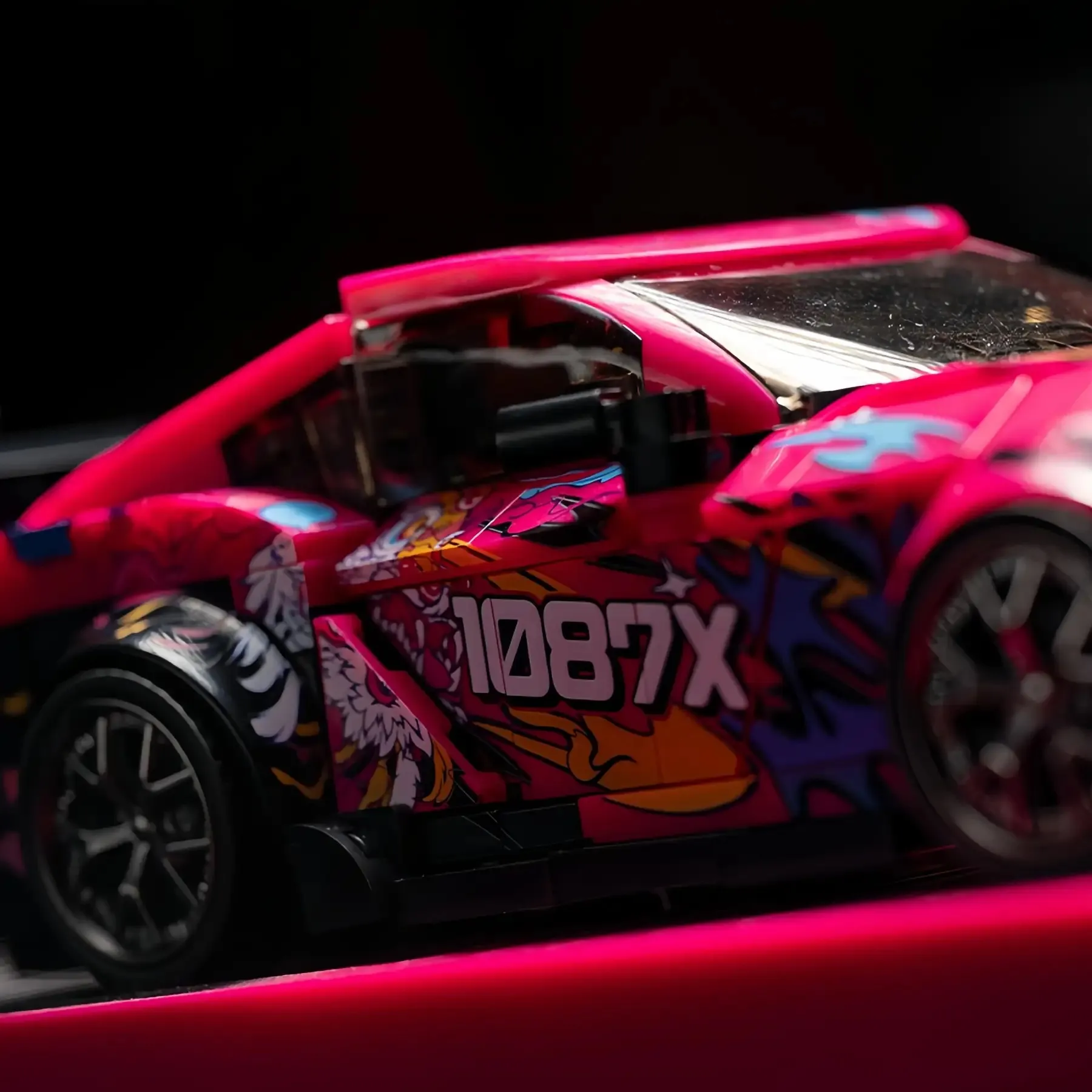 Close-up macro shot of the 1087X anime livery and side door details on Toyota Supra MK5 brick car.