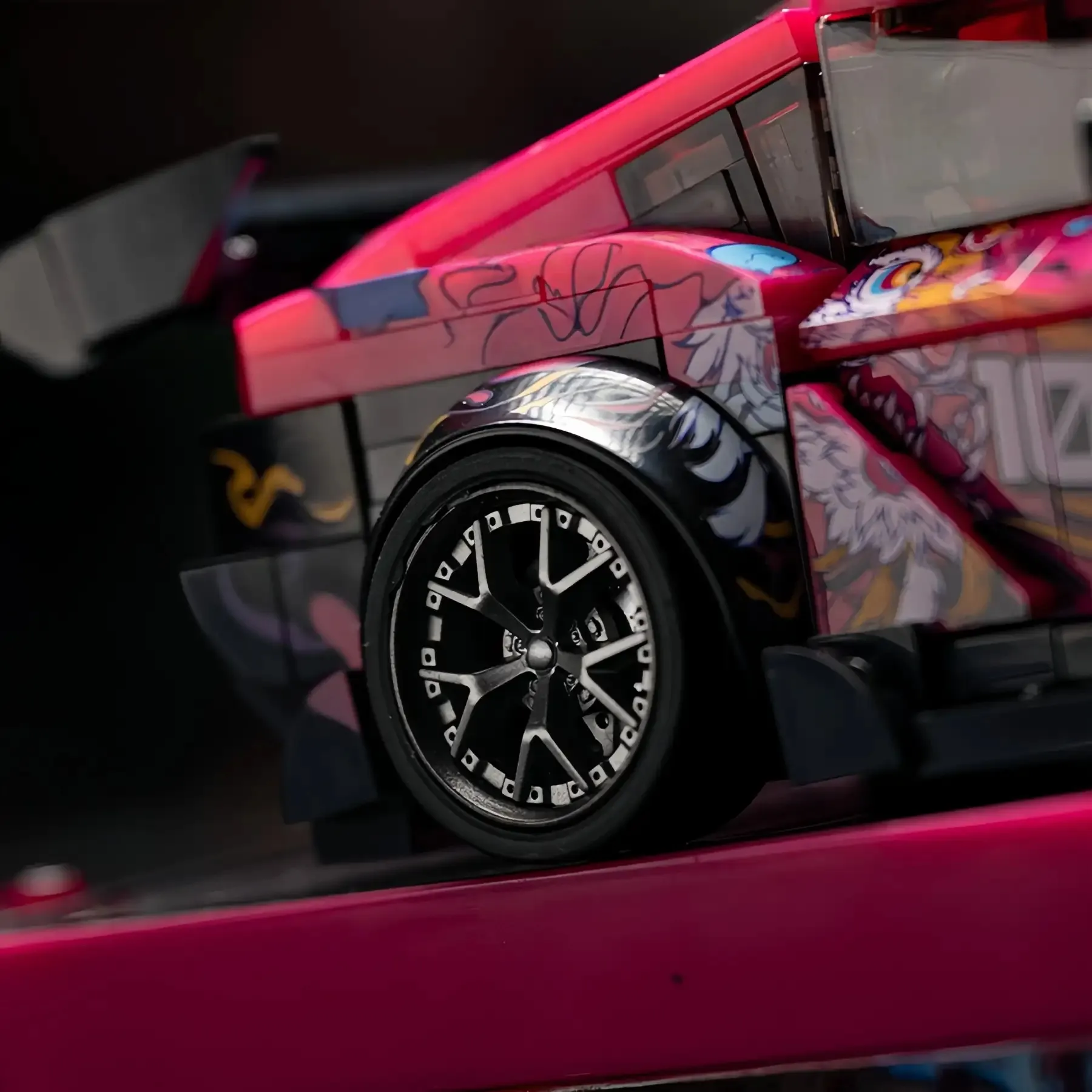 Macro detail shot of the custom gray wheel rim, brake caliper, and fender flare on 1:32 Supra brick car.