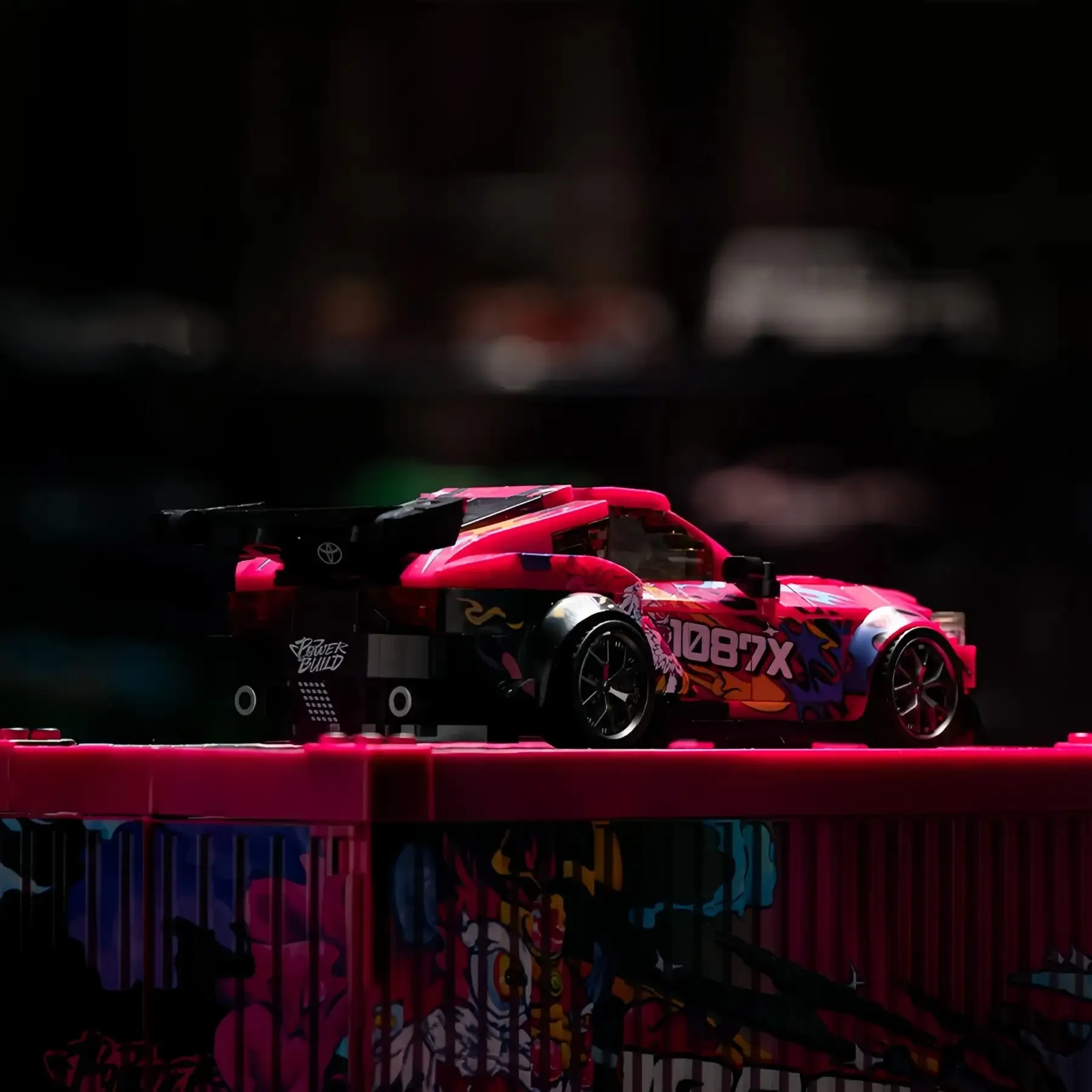 Rear angle of 1087X Toyota Supra MK5 brick model with GT wing on shipping container box.