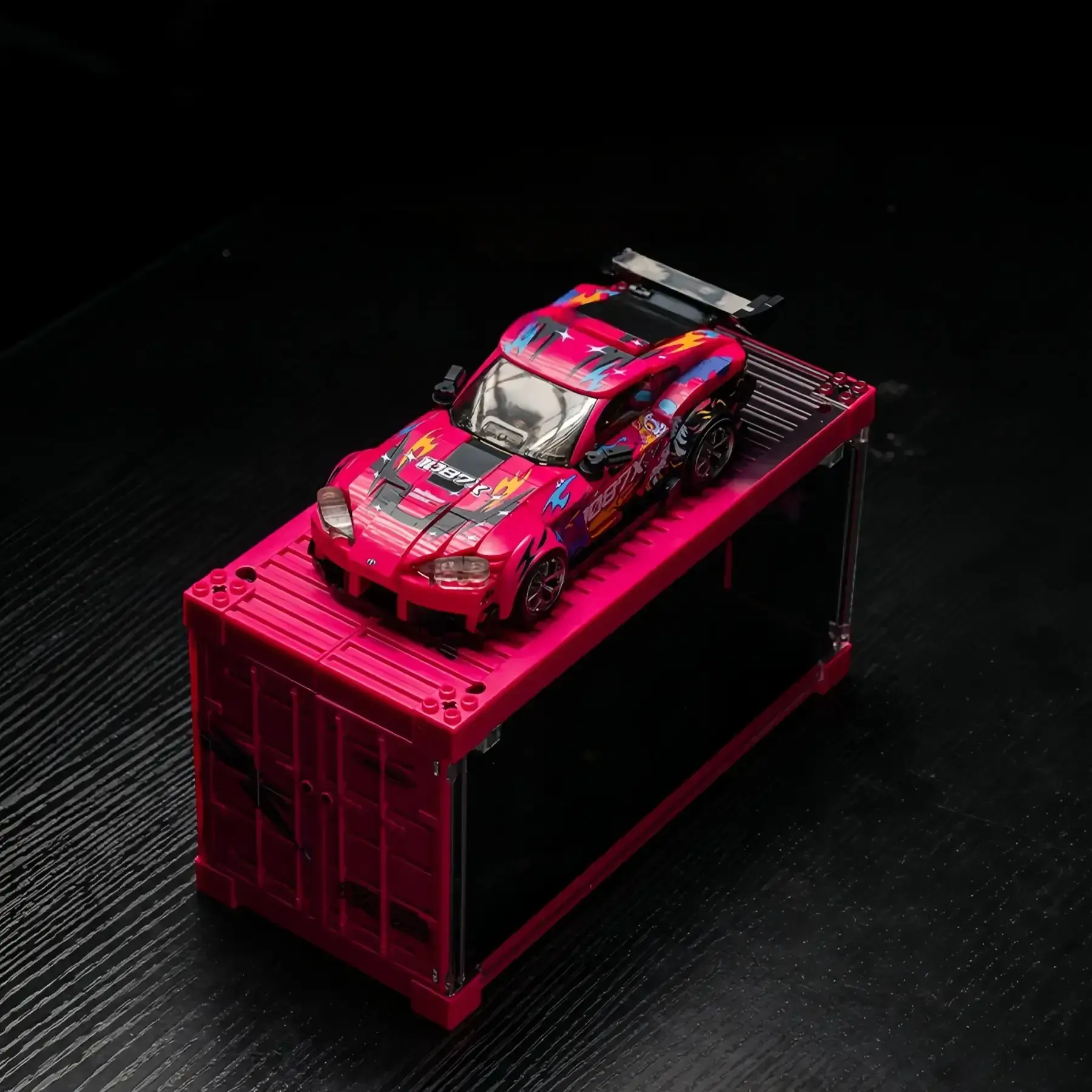 Top-down high angle view of the pink Toyota Supra MK5 brick car model on its shipping container showcase.